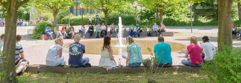 Martin-Schmeißer-Platz Studenten sitzen im Sommer am Brunnen des Martin-Schmeißer-Platzes